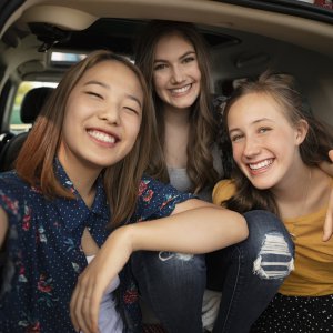 Portrait confident teenage girls taking selfie at back of car